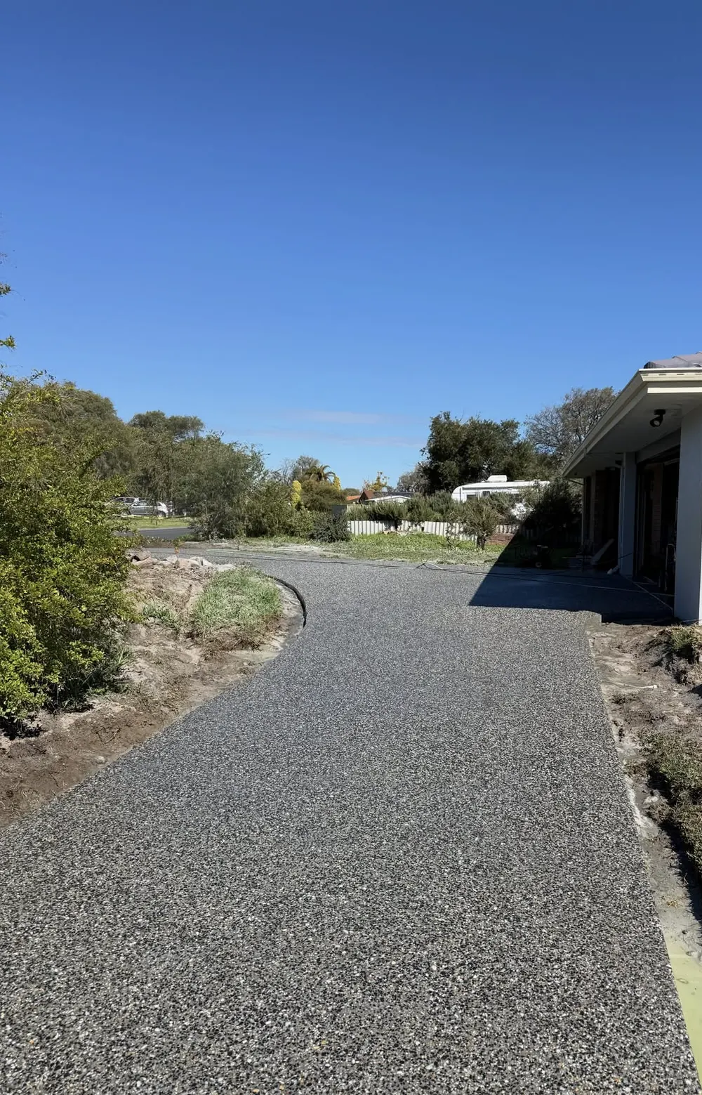 Exposed aggregate driveway curving toward the street