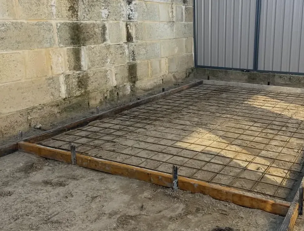 The same corner before the pour: timber formwork with mesh laid inside